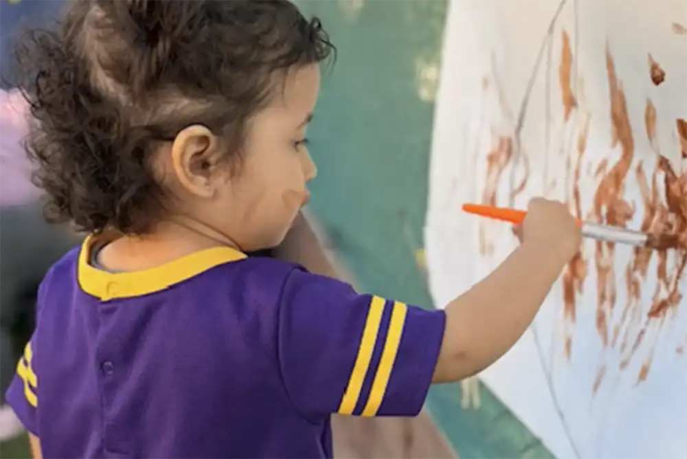 A young girl painting outside